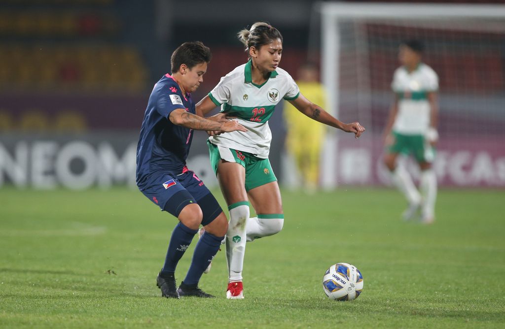 Penyerang Indonesia, Zahra Muzdalifah (kanan) berusaha mempertahankan penguasaan bola dari kawalan gelandang Filipina, Tahnai Annis, pada laga terakhir Grup B Piala Asia Putri 2022, Kamis (27/1/2022) malam WIB, di Stadion Kompleks Olahraga Shree Shiv Chhatrapati, Kota Pune, India. Indonesia menutup laga fase grup tanpa mampu meraih poin dan gagal mencetak gol dalam tiga laga.