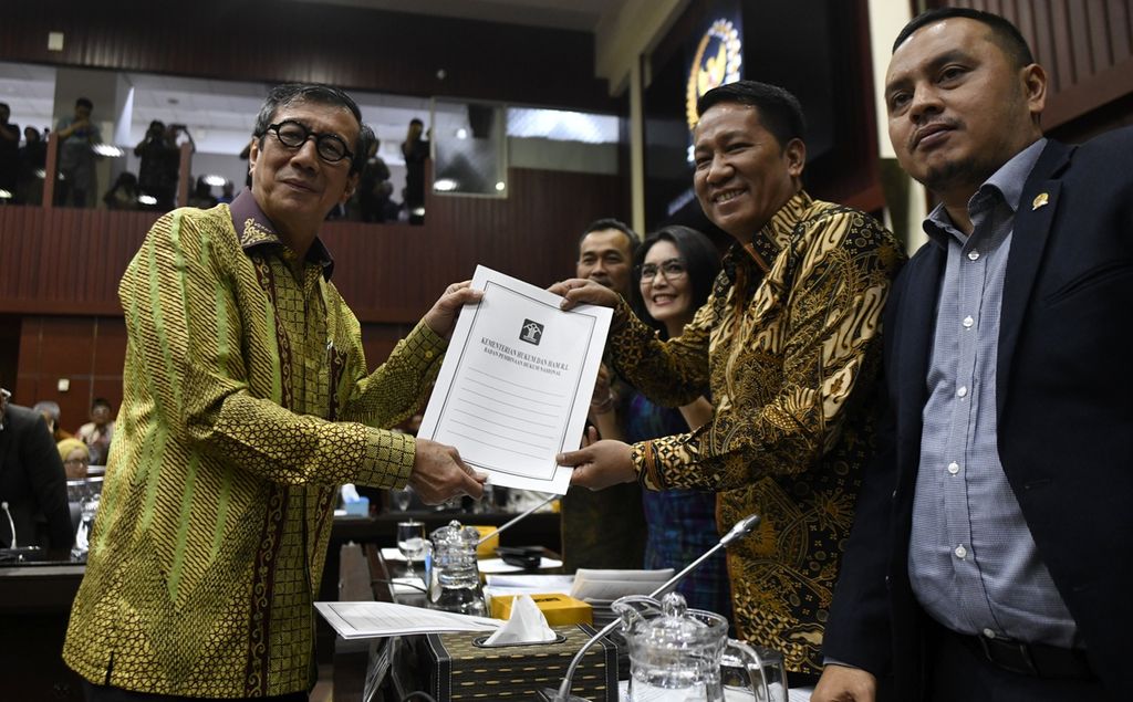 Menteri Hukum dan Hak Asasi Manusia (HAM) Yasonna Laoly menyerahkan daftar RUU Prolegnas kepada Ketua Badan Legislasi Supratman Andi Agtas dalam rapat di Kompleks Parlemen, Senayan, Jakarta, Kamis (5/12/2019). 