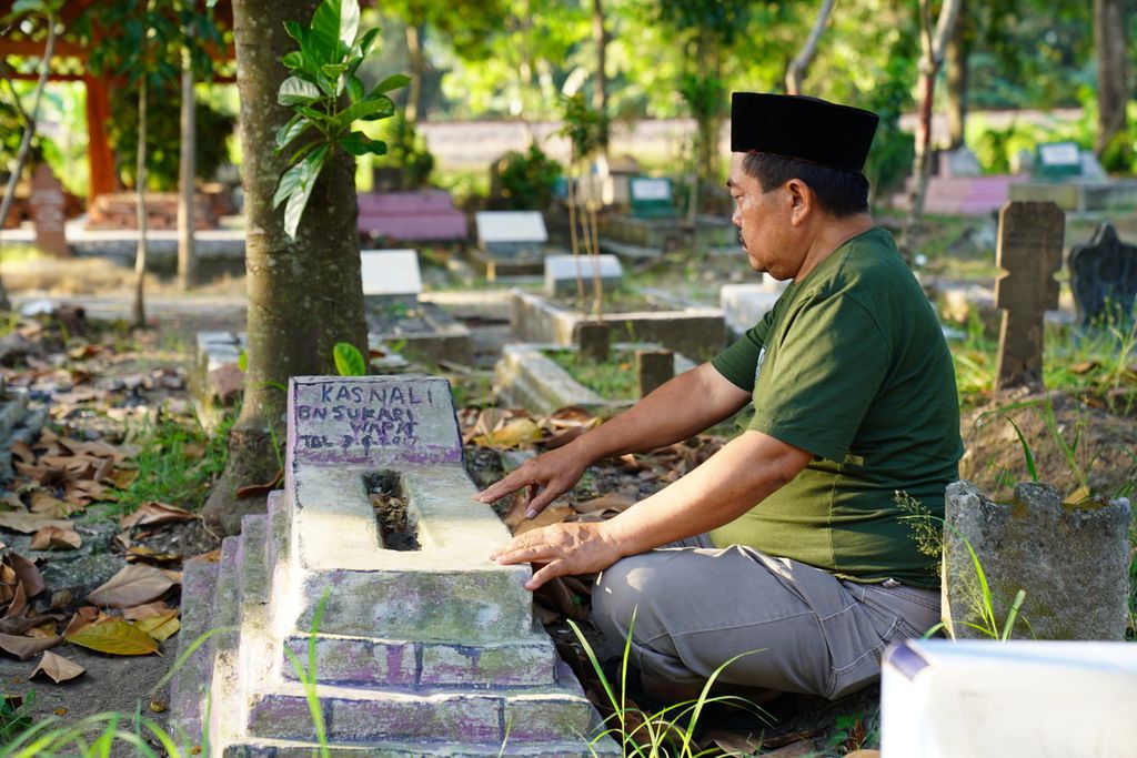 Sukari Tamin (53) berziarah ke makam anaknya, Kasnali, di TPU Banasari, Desa Gembongan, Kecamatan Babakan, Kabupaten Cirebon, Jawa Barat, Sabtu (22/7/2023). Kasnali merupakan anak buah kapal perikanan migran yang meninggal di Chile pada 2017 silam.