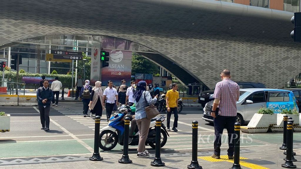 Beberapa masyarakat saat menyeberang di kawasan Jalan MH Thamrin, Jakarta Pusat, Senin (4/9/2023).