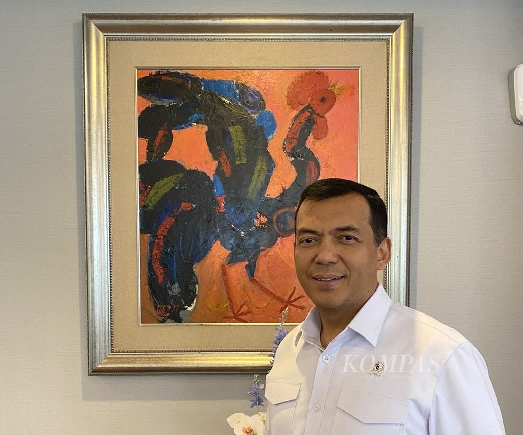 Silmy Karim, Wakil Menteri Imigrasi dan Pemasyarakatan, berpose di depan lukisan karya mendiang Popo Iskandar yang terpasang di ruang kerjanya, Kamis (31/10/2024).