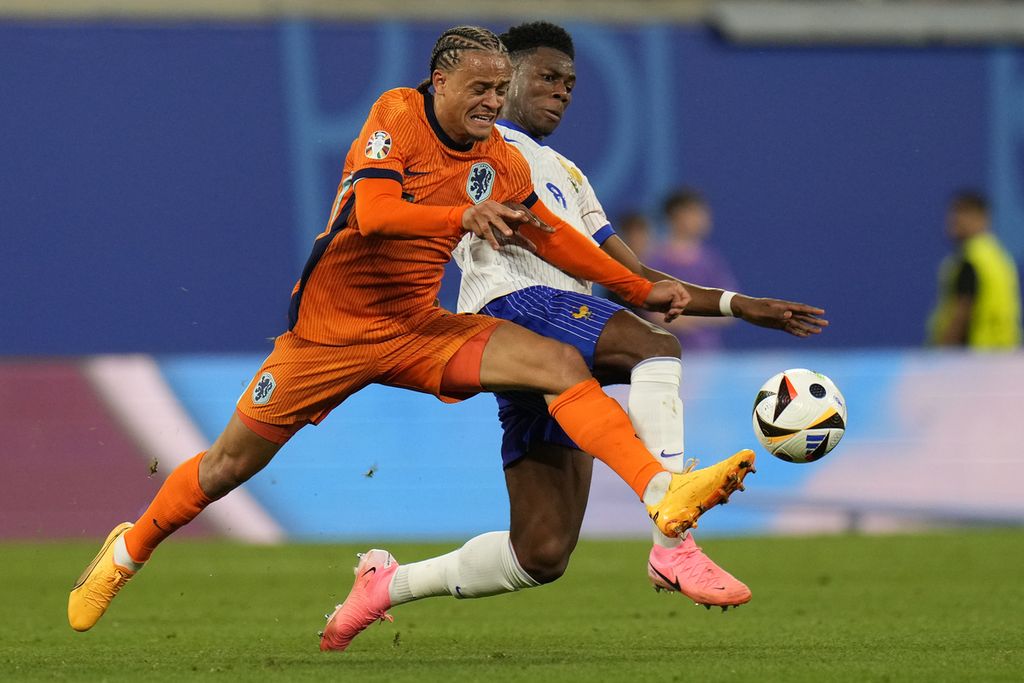 Gelandang Belanda Xavi Simons dan gelandang Perancis Aurelien Tchouameni berebut bola dalam pertandingan Grup D Piala Eropa 2024 antara Belanda dan Perancis di Leipzig, Sabtu (22/6/2024) dini hari WIB.