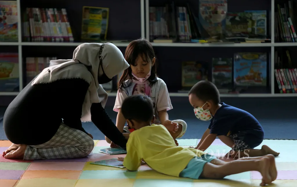 Orangtua mendampingi anak-anak membaca buku di Perpustakaan Umum dan Depo Arsip di Rawa Bunga, Jatinegara, Jakarta Timur, Selasa (28/12/2021). Sebagian anak-anak memilih untuk memanfaatkan waktu libur sekolah dengan mengunjungi perpustakaan umum. Selain membaca koleksi buku yang tersedia, mereka juga dapat menonton film-film edukatif yang diputar setiap hari. Perpustakaan ini menyediakan 17.000 koleksi buku kategori anak-anak. Keberadaan perpustakaan ini menjadi oase bagi anak-anak yang memiliki minat membaca. Selain menambah pengetahuan, membaca di waktu libur sekolah juga dapat mengurangi ketergantungan anak-anak terhadap gawai. Kompas/Riza Fathoni (RZF) 28-12-2021