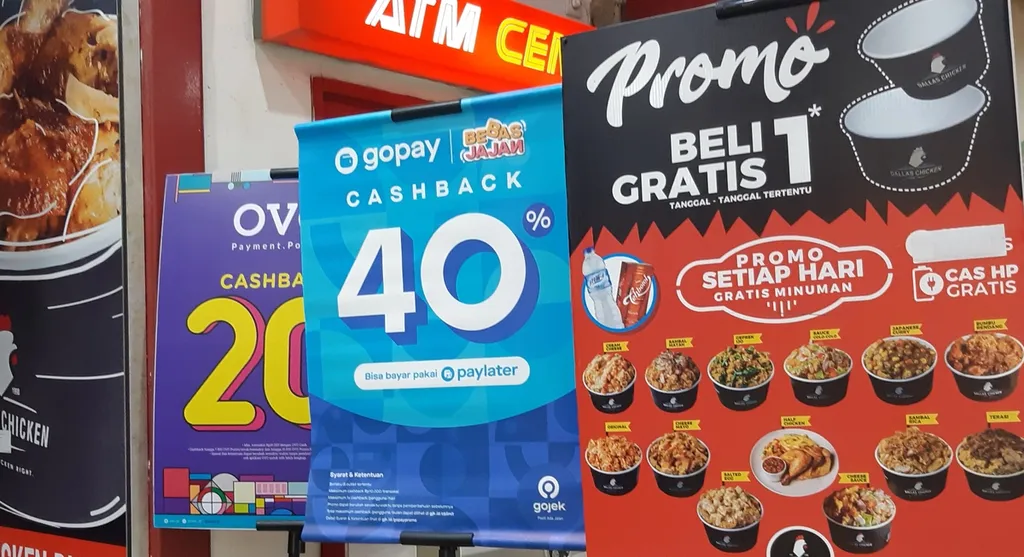 Papan promo layanan bayar kemudian atau paylater oleh dompet digital sebagai alat pembayaran mewarnai gerai-gerai penjualan makanan dan minuman.