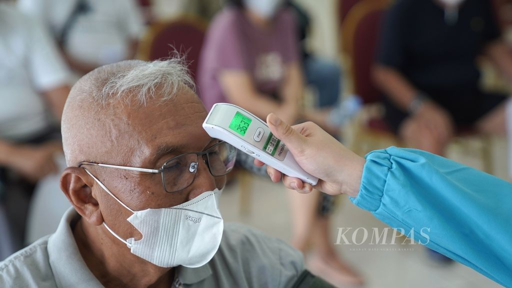 Warga lanjut usia diukur suhu tubuhnya sebelum menjalani vaksinasi penguat kedua di Gelanggang Olahraga Pulogadung, Jakarta Timur, pada 24 November 2022. 