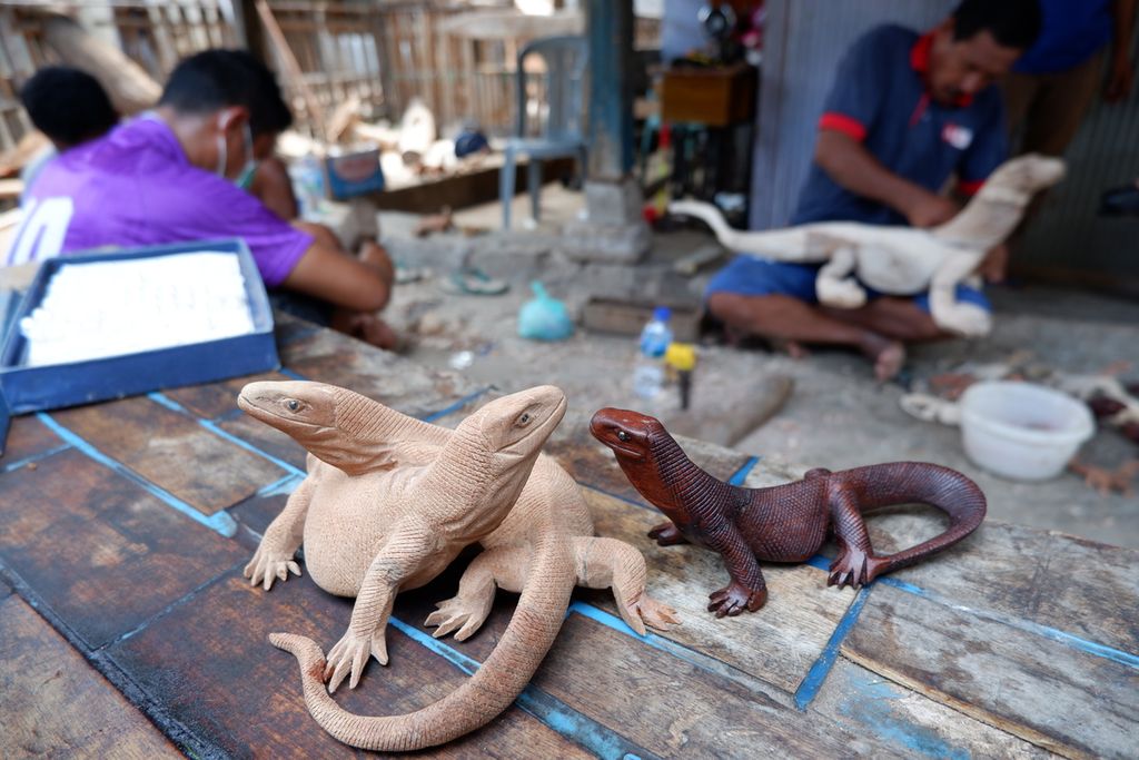 Ukiran komodo dari kayu di Pulau Komodo oleh seniman lokal. Komodo patung hasil karya manusia ini akan dijual kepada pengunjung sebagai oleh-oleh.