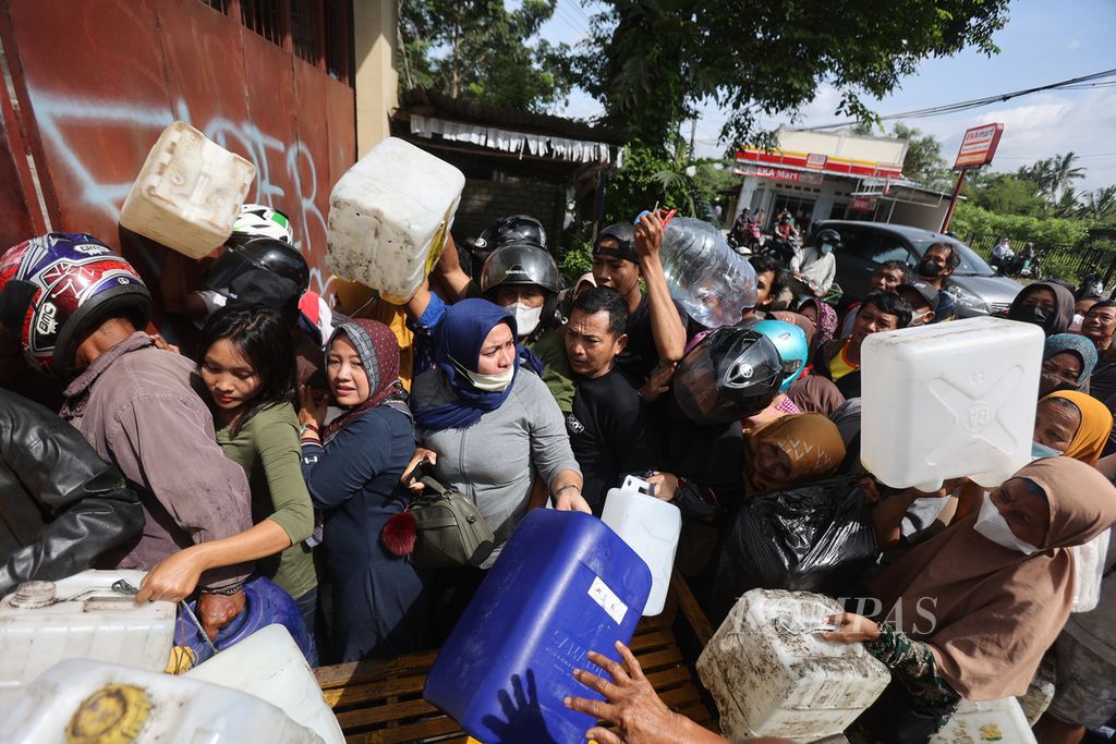 Warga berdesakan saat antre membeli minyak goreng di salah satu penyalur di Kecamatan Muntilan, Magelang, Jawa Tengah, Senin (21/3/2022). Pembelian minyak goreng seharga Rp 15.500 per kilogram di tempat itu dibatasi 16 kilogram per orang. Menurut warga, minyak goreng dengan harga murah terus diburu karena semakin susah diperoleh. Harga minyak goreng di pasaran setempat saat ini sekitar Rp 25.000 per kilogram.