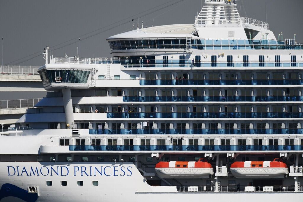 Para penumpang kapal pesiar Diamond Princess yang berlabuh di Pelabuhan Yokohama, Jepang, berdiri di balkon kabin mereka, Senin (10/2/2020).