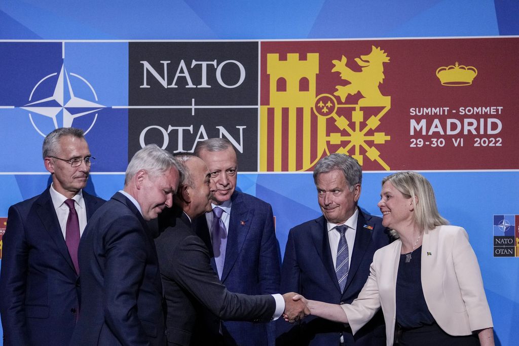 Menteri Luar Negeri Turki Mevlut Cavusoglu (tiga dari kiri) berjabat tangan dengan Perdana Menteri Swedia Magdalena Andersson (kanan) disaksikan Presiden Turki Recep Tayyip Erdogan (tiga dari kanan), Presiden FInlandia Sauli Siniisto (dua dari kanan) dan Sekjen NATO Jens Stoltenberg (kiri) usai menandatangani Nota Kesepahaman soal keanggotaan Swedia dan Finlandia ke NATO di Madrid, Spanyol, Selasa (28/6/2022).