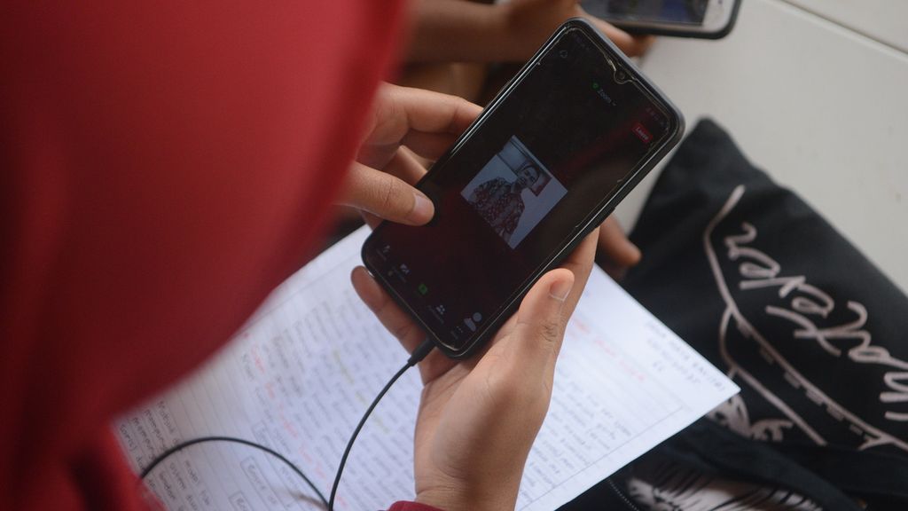 Erna Maya Zavitri (20), mahasiswi IAIN Salatiga, mengikuti perkuliahan daring menggunakan aplikasi Zoom melalui gawai yang terhubung dengan jaringan internet nirkabel di Balai Desa Banyuanyar, Kecamatan Ampel, Boyolali, Jawa Tengah, Kamis (1/4/2021). Sejak sekitar tahun 2017 seluruh warga desa itu memperoleh layanan internet gratis melalui jaringan nirkabel yang disediakan oleh pemerintah desa setempat. Penyediaan infrastruktur layanan internet gratis tersebut memanfaatkan kucuran Dana Desa dari Pemerintah. Saat ini terdapat 21 titik lokasi penyebaran jaringan internet nirkabel yang tersebar di berbagai tempat di desa tersebut.