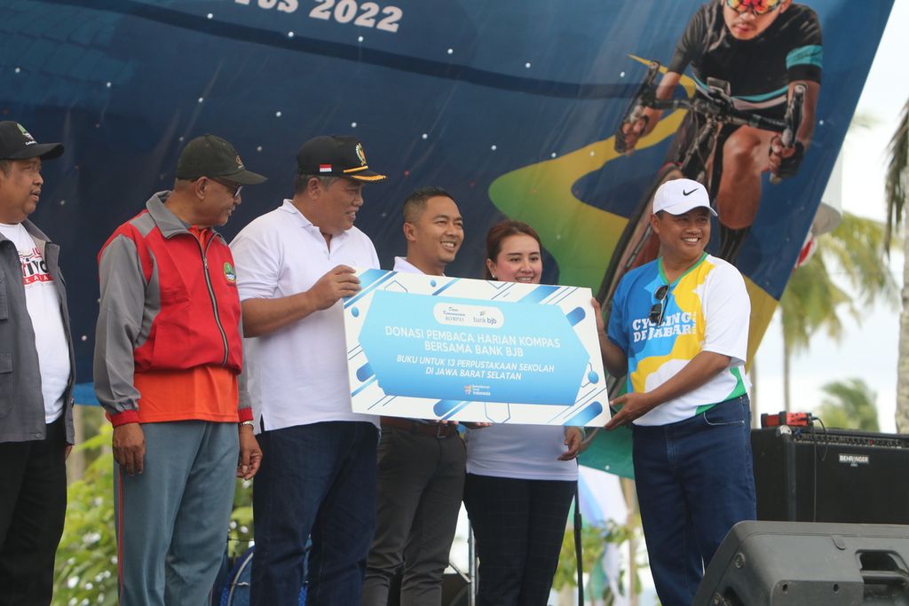 Wakil Gubernur Jawa Barat Uu Ruzhanul Ulum (topi putih) memberikan bantuan secara simbolis bantuan buku dari Dana Kemanusiaan <i>Kompas </i>dan Bank BJB kepada sejumlah sekolah di Jabar bagian selatan dalam Ajang Cycling De Jabar 2022 di Alun-alun Paamprokan, Pantai Pangandaran, Kabupaten Pangandaran, Jabar, Minggu (27/8/2022).