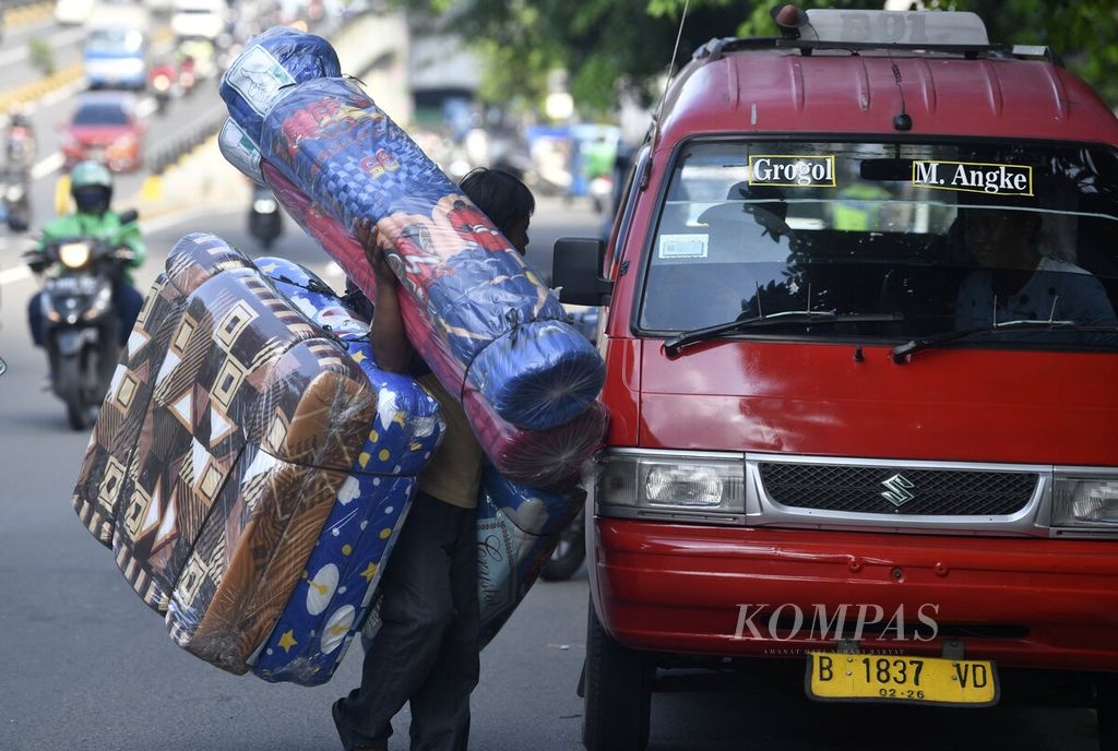 Penjual kasur keliling membawa dagangan berkeliling di daerah Grogol, Jakarta Barat, Rabu (8/12/2021). 