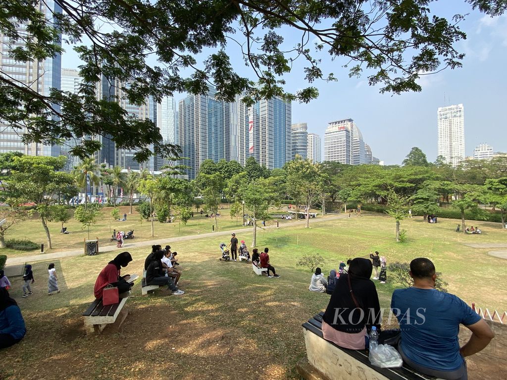Warga duduk bersantai setelah berolahraga di Hutan Kota Gelora Bung Karno (GBK), Jakarta, Minggu (30/7/2023). 