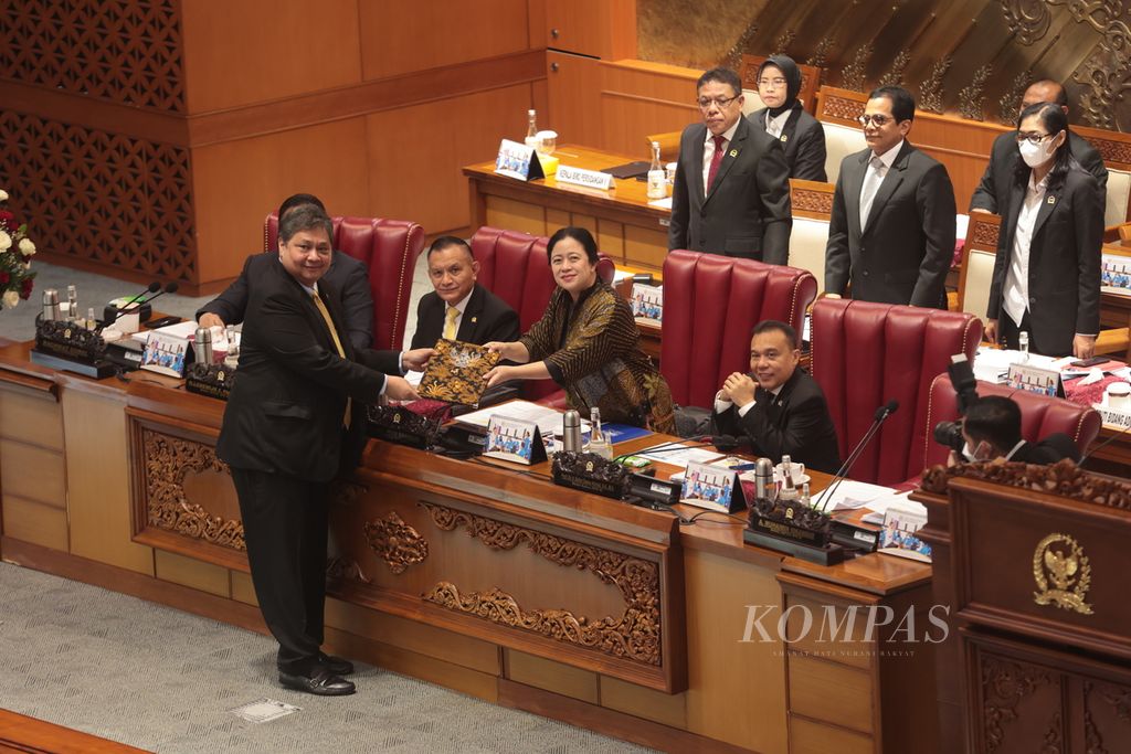 Menteri Koordinator Perekonomian Airlangga Hartarto (kiri) menyerahkan pandangan pemerintah kepada Ketua DPR Puan Maharani saat rapat paripurna di Kompleks Parlemen, Senayan, Jakarta, Selasa (21/3/2023). DPR menyetujui Peraturan Pemerintah Pengganti Undang-Undang atau Perppu Nomor 2 Tahun 2022 tentang Cipta Kerja menjadi undang-undang. Fraksi Partai Demokrat dan Fraksi Partai Keadilan Sejahtera menolak pengesahan itu. Rapat dihadiri 75 anggota DPR secara fisik, sebanyak 210 hadir secara daring, dan 95 orang tidak hadir dan izin.