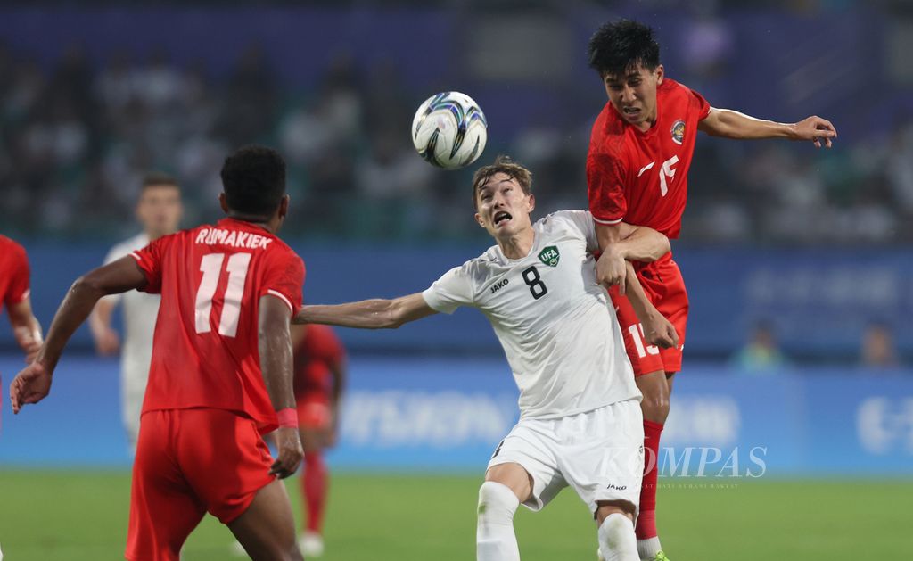 The Uzbekistan U-24 player, Ibrokhim Ibragimov, is flanked by two Indonesian U-24 players, Ranai Rumakiek (left) and Muhammad Taufany Muslihuddin, during the Asian Games 2022 round of 16 football match at the Shancheng Sports Centre Stadium in Hangzhou, China, on Thursday (28/9/2023). Indonesia lost 0-2 to Uzbekistan.