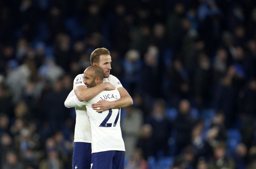 Pemain Tottenham Hotspur, Harry Kane, memeluk rekannya, Lucas Moura, pada akhir pertandingan Liga Inggris antara Manchester City dan Tottenham Hotspur di Stadion Etihad, Manchester, Minggu (20/2/2022) dini hari WIB. Tottenham mempermalukan City di kandangnya, 3-2, antara lain dengan dua gol yang disumbangkan Kane.