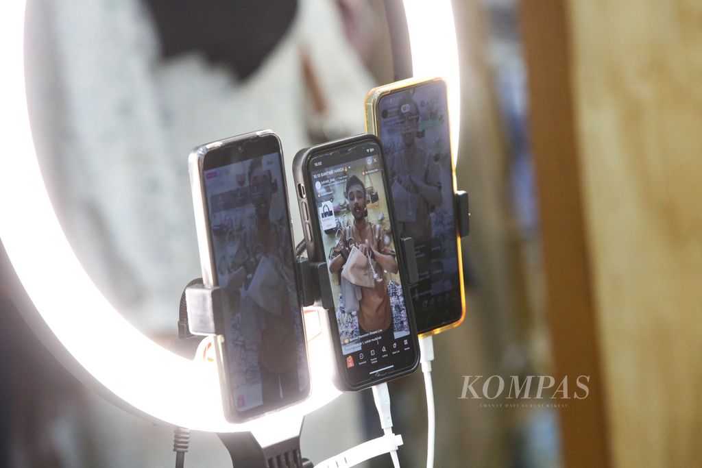 Tampilan di layar telepon seluler saat pedagang menawarkan produk tas wanita melalui siaran langsung di lokapasar pada Hari Belanja Nasional (Harbolnass) 10.10 di kiosnya di sebuah pusat perbelanjaan di kawasan Tanah Abang, Jakarta Pusat, Kamis (10/10/2024). 