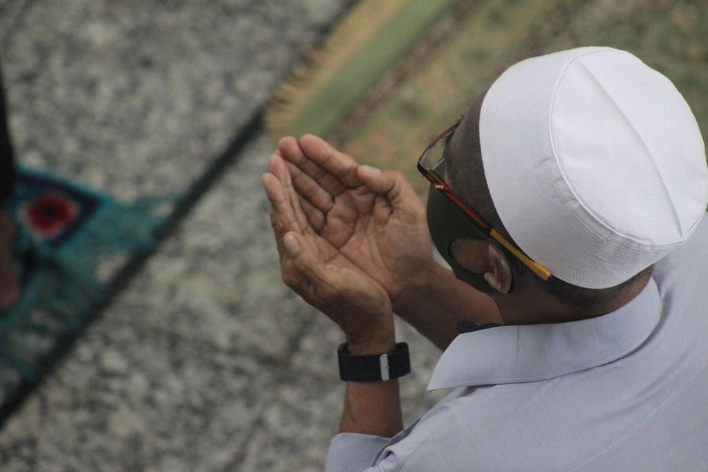 Seorang anggota jemaah sedang mengikuti shalat Jumat di Masjid Agung Palembang, Sumatera Selatan, Jumat (5/6/2020). Dia tampak menggunakan masker dengan tangan menengadah. Ini adalah shalat Jumat pertama dalam dua bulan terakhir karena Palembang masuk dalam zona merah pandemi Covid-19.