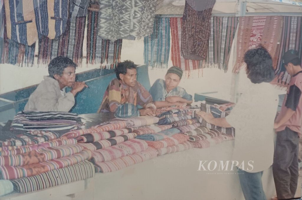 Kain tais atau tenun ikat Timor Timur, yang dipajang di Desa Kolmera, Dili, Juli 1998. Dua pembeli sedang menawar harga tais yang dijual warga asli Dili.