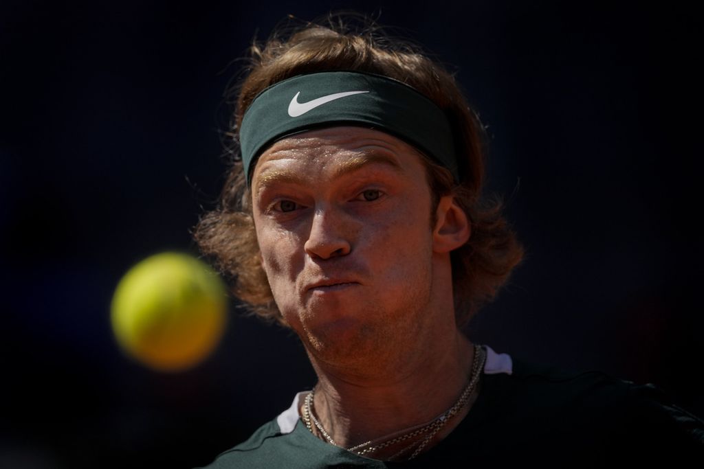 Andrey Rublev, petenis Rusia, membidik bola saat menghadapi Daniel Evans (Inggris) pada turnamen Madrid Terbuka di Spanyol, Kamis (5/5/2022) lalu. 