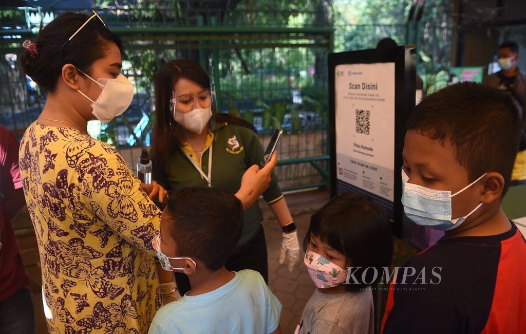 Pengunjung mengakses aplikasi Peduli Lindungi saat akan masuk Kebun Binatang Surabaya, Jawa Timur, Minggu (3/10/2021). Pada hari tersebut, Kebun Binatang Surabaya kembali dibuka untuk umum. KBS dibuka pukul 08.00-16.00 dengan kapasitas 25 persen dari total kapasitas pengunjung atau sekitar 2.000 orang. Bagi pengunjung yang belum vaksin disediakan juga vaksin sebanyak 1.000 dosis. 