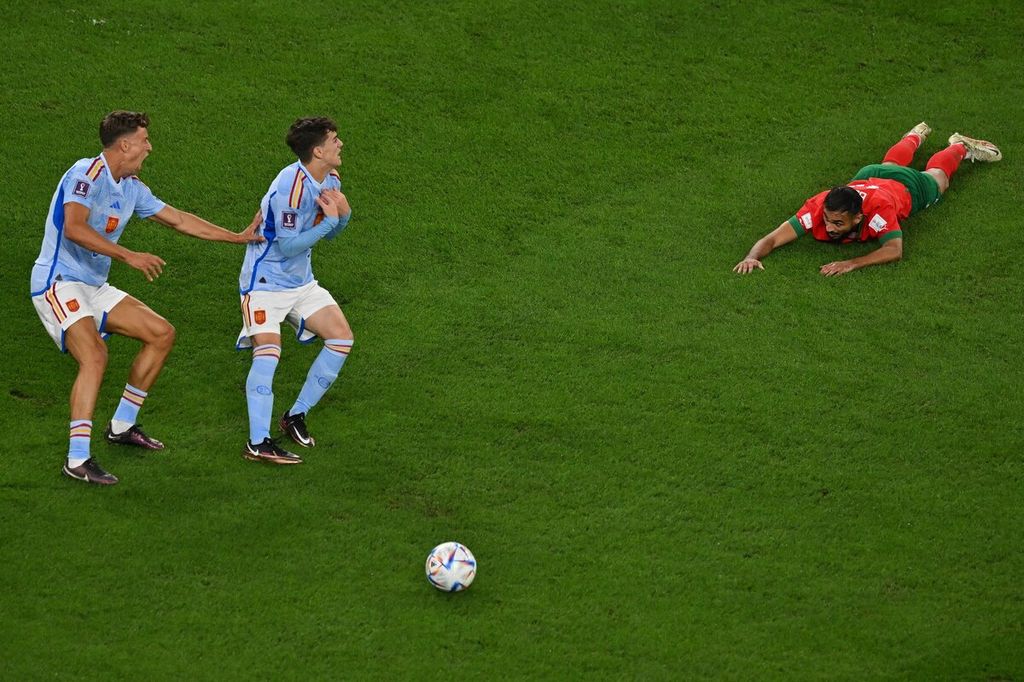 Reaksi pemain Spanyol Marcos Llorente dan Gavi saat wasit meniup peluit melihat pemain Maroko Sofiane Boufal terjatuh di lapangan dalam pertandingan babak 16 besar Piala Dunia Qatar 2022 di Stadion Education City di Al-Rayyan, Qatar, Selasa (6/12/2022).