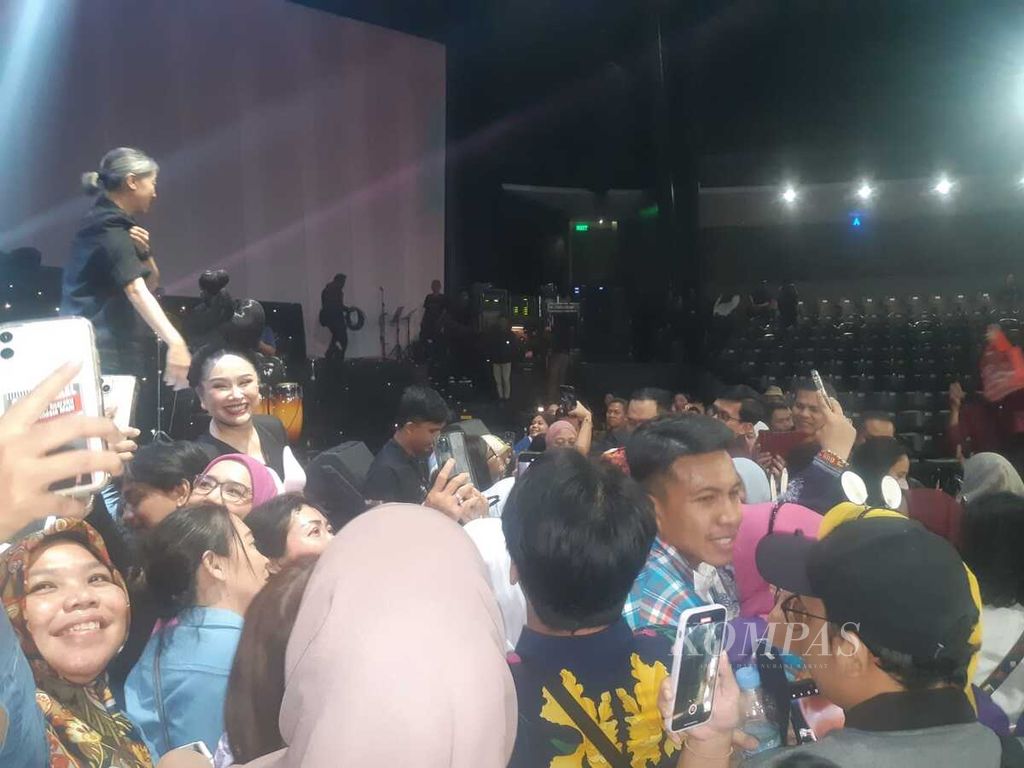 Biduanita kawakan Titi DJ melayani penggemar yang ingin berfoto bersama seusai konsernya di Jakarta, Jumat (15/9/2023).