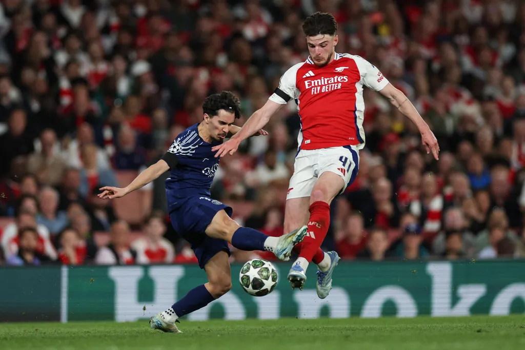 Paris Saint-Germain's Portuguese midfielder #17 Vitinha (L) fights for the ball with Arsenal's English midfielder #41 Declan Rice during the UEFA Champions League Semi-final First Leg football match between Arsenal and Paris Saint-Germain (PSG) at the Emirates Stadium in north London, on April 29, 2025. (Photo by Adrian Dennis / AFP)