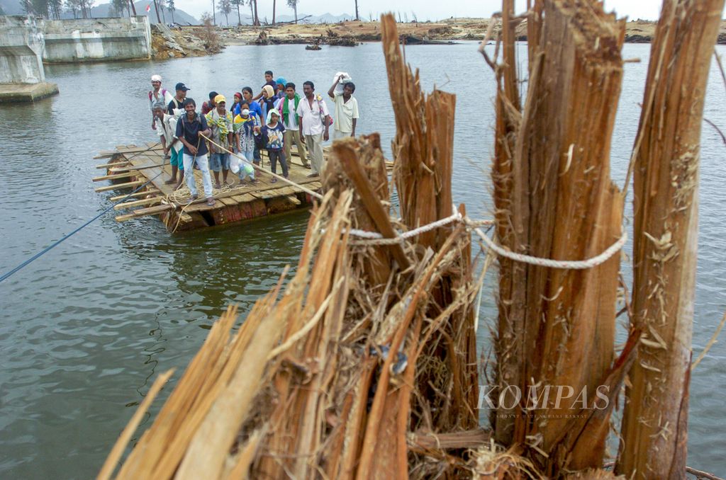 Sejumlah warga pantai barat Nanggroe Aceh Darussalam yang selamat dari hantaman gempa dan tsunami tengah menggunakan rakit menyeberangi sungai di Lhoknga, Kabupaten Aceh Besar, Senin (10/01/2005). Mereka melakukan perjalanan panjang dengan berjalan kaki selama 14 hari dari Meulaboh menuju Banda Aceh. 