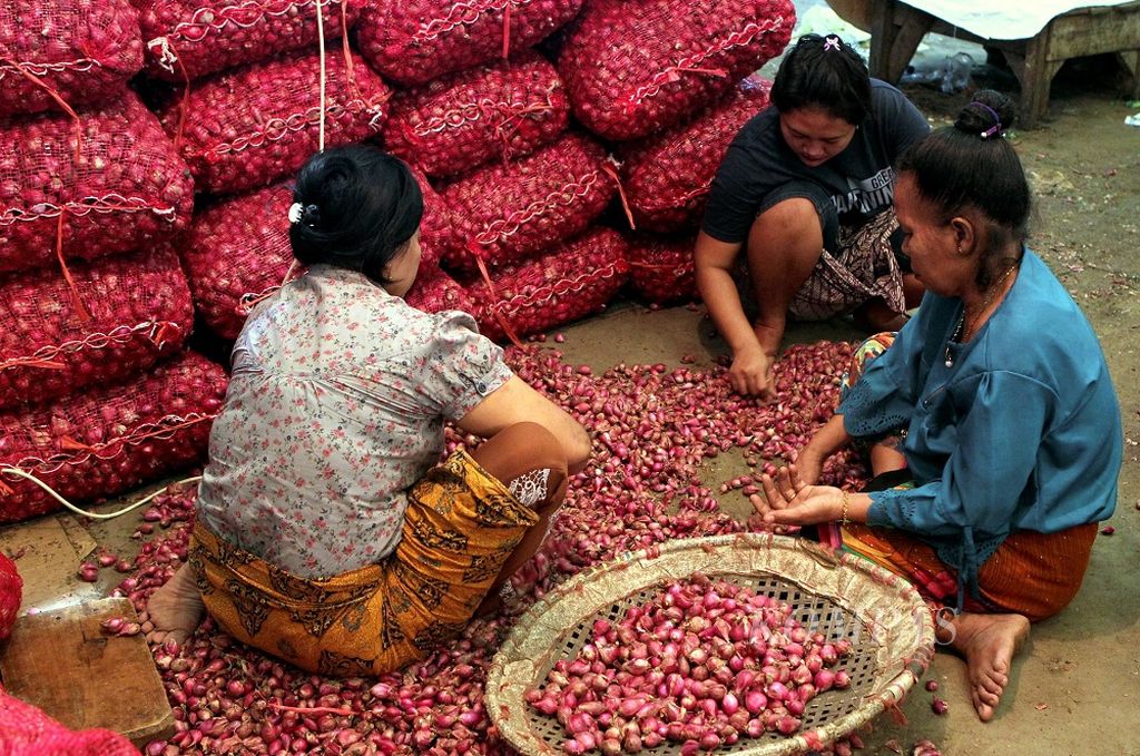 Buruh mengupas dan menyortir bawang merah yang akan dijual di Pasar Induk Kramat Jati, Jakarta, Minggu (15/12/2019). Menjelang Natal dan Tahun Baru 2020, harga bawang merah naik dari Rp 28.000 per kilogram menjadi Rp 35.000 per kilogram. Beberapa bahan pangan lain juga mengalami kenaikan harga.