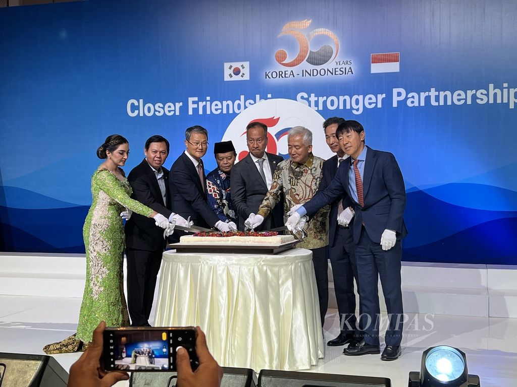 Duta Besar Korea Selatan untuk Indonesia Lee Dang Deok (tiga dari kanan mengenakan batik), Menteri Perindustrian Agus Gumiwang Kartasasmita (empat dari kanan) beserta sejumlah tokoh seperti Pelatih Timnas Indonesia asal Korsel Shin Tae Yong (paling kanan), Wakil Ketua MPR RI Hidayat Nur Wahid (berpeci, berdiri di samping Menperin) dan penyanyi Ashanti (paling kiri), bersama-sama memotong kue perayaan 50 Tahun Hubungan Diplomatik RI-Korea Selatan di Jakarta, Senin (18/9/2023). 
