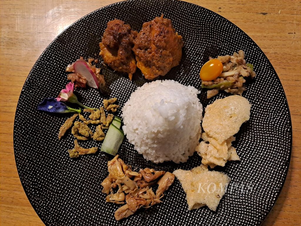 Sepiring nasi dengan beragam lauk khas tradisional dari lima wilayah provinsi di Kalimantan, salah satunya tumis daun kunyit muda atau bunga kunyit dengan ikan asin telang fermentasi asal Kalimantan Barat. Menu itu tampak di posisi arah pukul dua, dengan tambahan tomat ceri. 