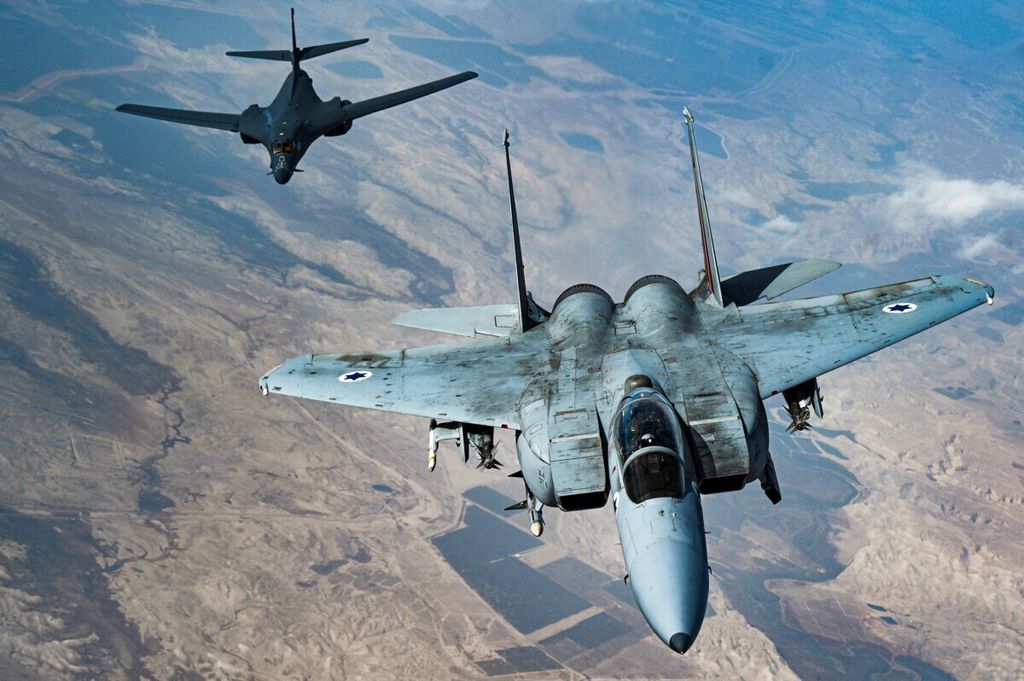 Dalam foto yang dirilis Angkatan Udara Amerika Serikat, pesawat F-15 Strike Eagle terbang di depan bomber B-1B Lancer, Sabtu, 30 Oktober 2021. <i>Bomber</i> memiliki beberapa makna, antara lain pesawat pengebom.