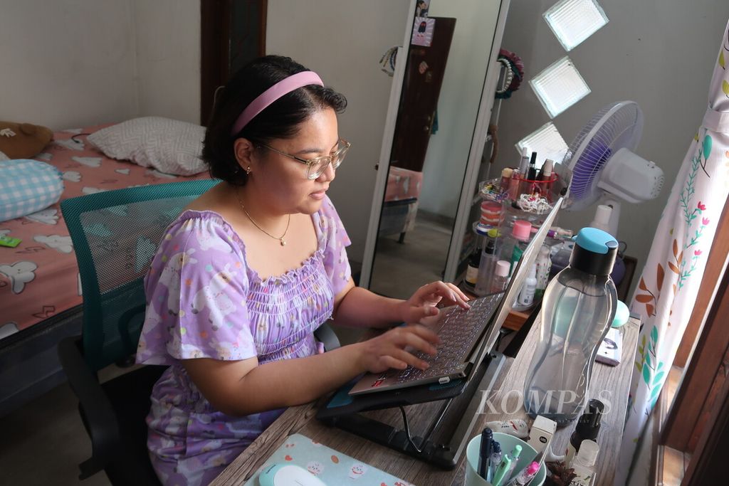 Intan Aprilia (28), seorang pekerja muda, bekerja dari rumahnya di Sudimara Pinang, Tangerang, Banten, Kamis (12/1/2023). Intan merupakan salah satu pekerja muda yang memilih kantor yang menawarkan pekerjanya bisa bekerja dari mana saja. Saat ini, dia bekerja di Fita, sebuah perusahaan rintisan bidang teknologi kesehatan yang berkantor di Kemang, Jakarta. Intan biasa bekerja dari rumah dan kafe.