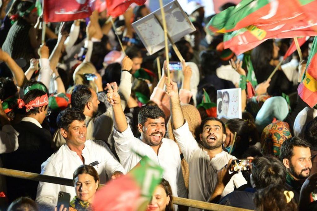 Para pendukung mantan PM Pakistan dan Ketua Partai Tehreek-e-Insaf Pakistan (PTI) Imran Khan, melambaikan bendera dalam sebuah aksi protes anti-pemerintahan Perdana Menteri Shehbaz Sharif di Islamabad, 20 Agustus 2022. 