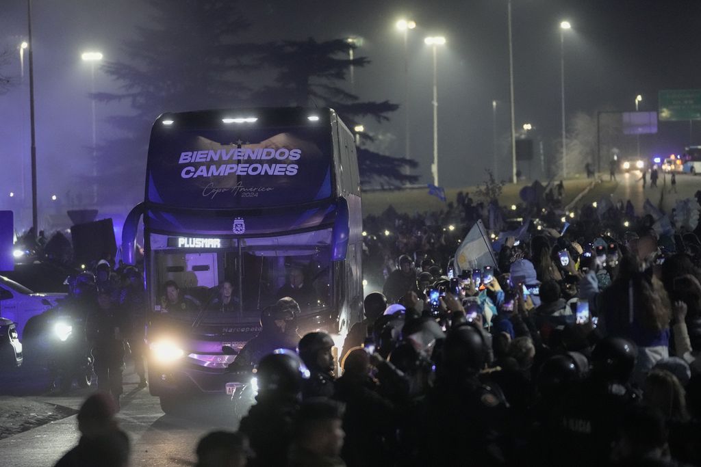 Bus yang membawa pemain dan ofisial tim Argentina yang menjuarai Copa America melintasi jalan saat tiba di Buenos Aires, Argentina, Senin (15/7/2024) malam waktu setempat atau Selasa siang WIB.