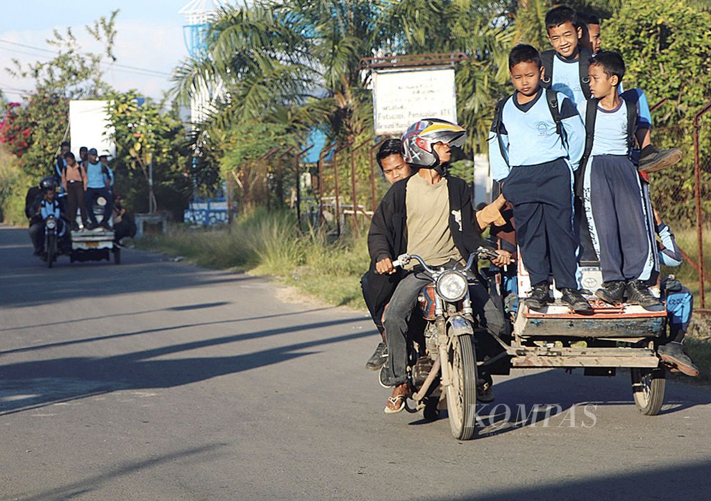 Murid-murid berangkat ke sekolah dengan berdesakan di dalam dan badan becak bermotor di Kecamatan Pinangsori, Kabupaten Tapanuli Tengah, Sumatera Utara, Jumat (31/3/2017). Minimnya mobil angkutan umum membuat para murid terpaksa berdesakan di becak. 