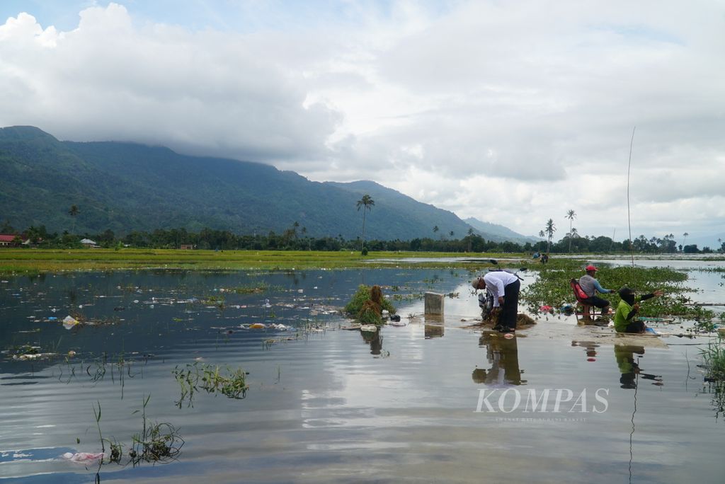 Warga memancing di areal persawahan yang tergenang banjir akibat meluapnya Danau Kerinci di Desa Pulau Tengah, Kecamatan Keliling Danau, Kabupaten Kerinci, Jambi, Selasa (16/1/2024). 