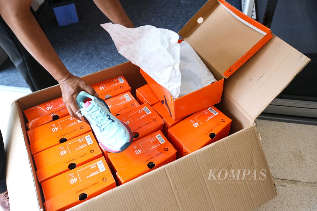 Pramuniaga memeriksa stok sepatu dalam Lokal Hood yang menjadi bagian dari Wondr Jakarta Running Festival 2024 di Istora, Jakarta, Jumat (11/10/2024).