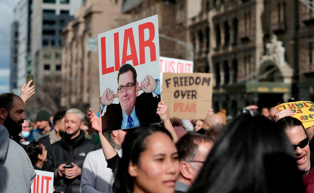 Pengunjuk rasa membawa poster Perdana Menteri Australia Scott Morrison saat bergabung dalam aksi protes menolak <i>lockdown </i>di Melbourne, Australia, Sabtu (24/7/2021).