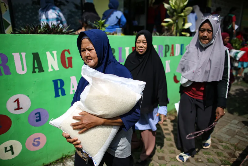 Warga membawa bantuan beras tahap ke enam yang disalurkan di RPTRA Petukangan Berseri di Kelurahan Petukangan Utara, Kecamatan Pesanggrahan, Jakarta Selatan, Kamis (13/6/2024). Bantuan pangan dari cadangan beras pemerintah ini diperlukan sebagai perlindungan sosial dan penjaga stabilitas harga pangan.