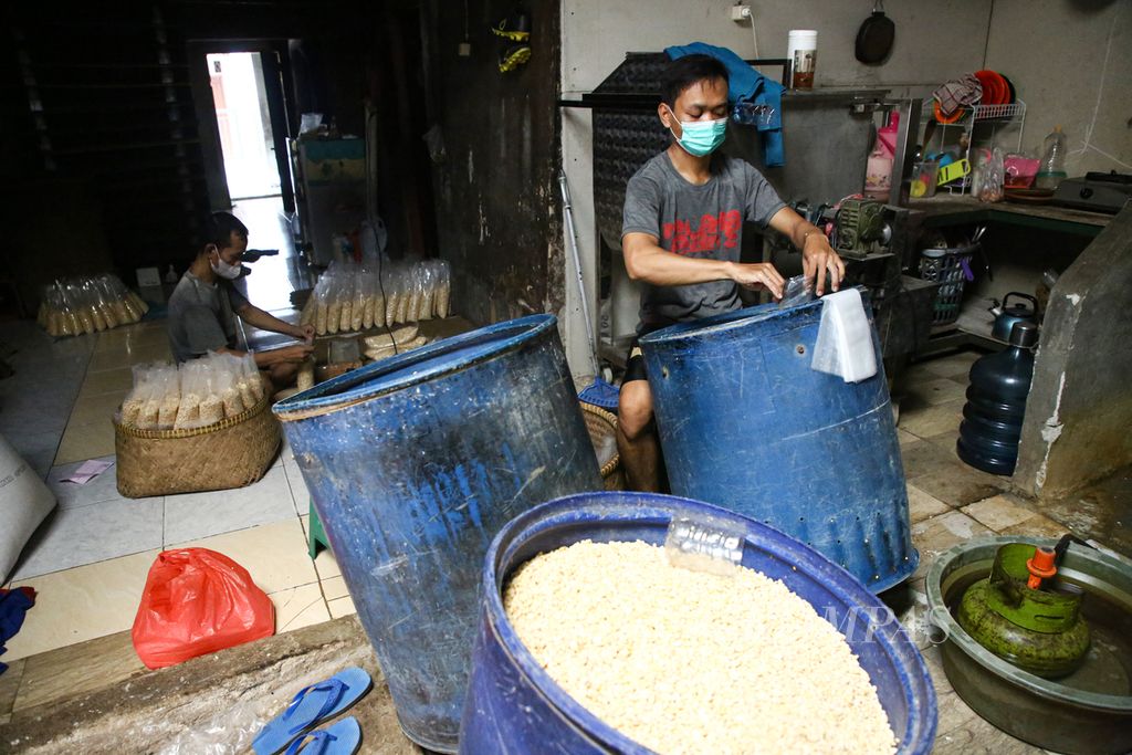 Perajin tempe mengemas kedelai impor untuk dibuat tempe di sentra indutri tempe di kawasan Kebayoran Lama, Jakarta selatan, Sabtu (4/9/2021). Tempe produksi mereka dijual ke pasar Kebayoran Lama dengan harga Rp 8000 per buah.