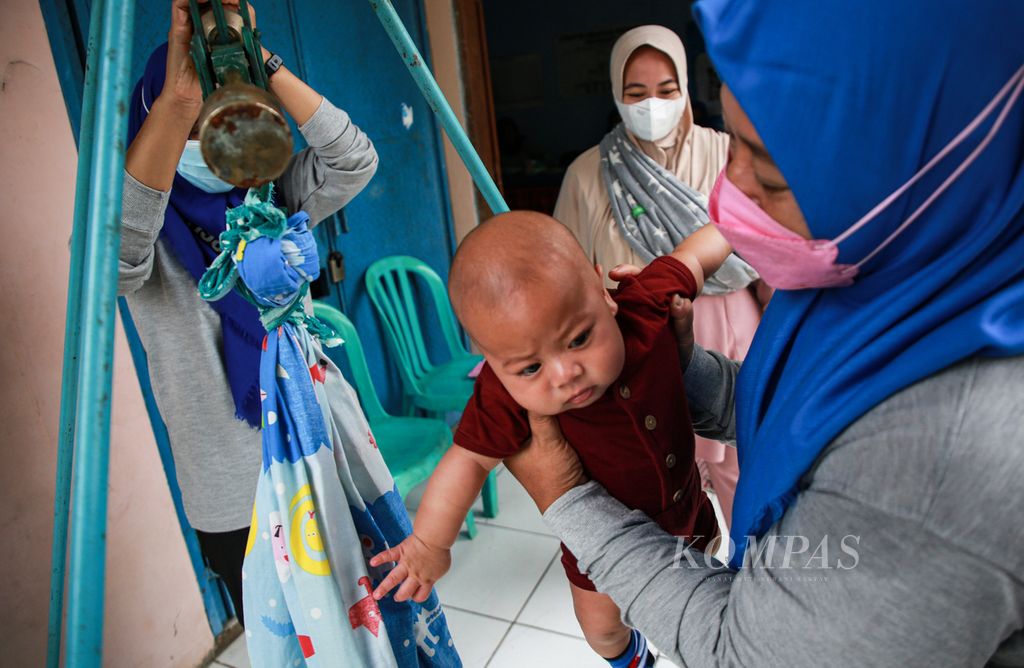 Kader posyandu menimbang bayi di Posyandu Mawar di RW 004 Kampung Bulak Wareng, Larangan Selatan, Larangan, Kota Tangerang, Banten, Jumat (8/4/2022). Kegiatan ini rutin dilakukan setiap bulan. Selain penimbangan, juga dilakukan kegiatan pemberian obat cacing, vitamin A, dan makanan tambahan bagi anak balita secara berkala.