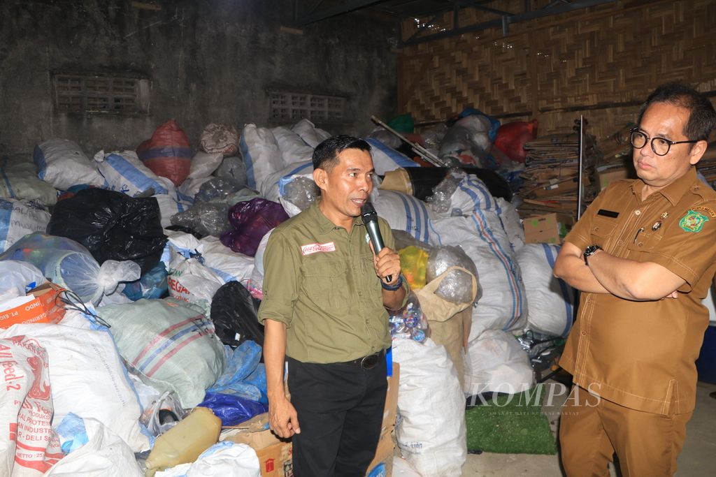 Direktur Bank Sampah New Normal Yasra Al-Fajar (kiri) dan Kepala Dinas Lingkungan Hidup dan Kebersihan Pemerintah Kota Medan Suryadi Panjaitan melihat pengelolaan bank sampah pada acara Apresiasi dan Pertemuan Tahunan Bank Sampah, di Medan, Sumatera Utara, Selasa (24/1/2023). 