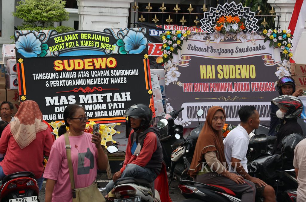 Karangan bunga berisi kritikan dan kecaman terhadap Bupati Pati Sudewo yang diletakkan di depan Kantor Bupati Pati, Kabupaten Pati, Jawa Tengah, Selasa (12/8/2025). 