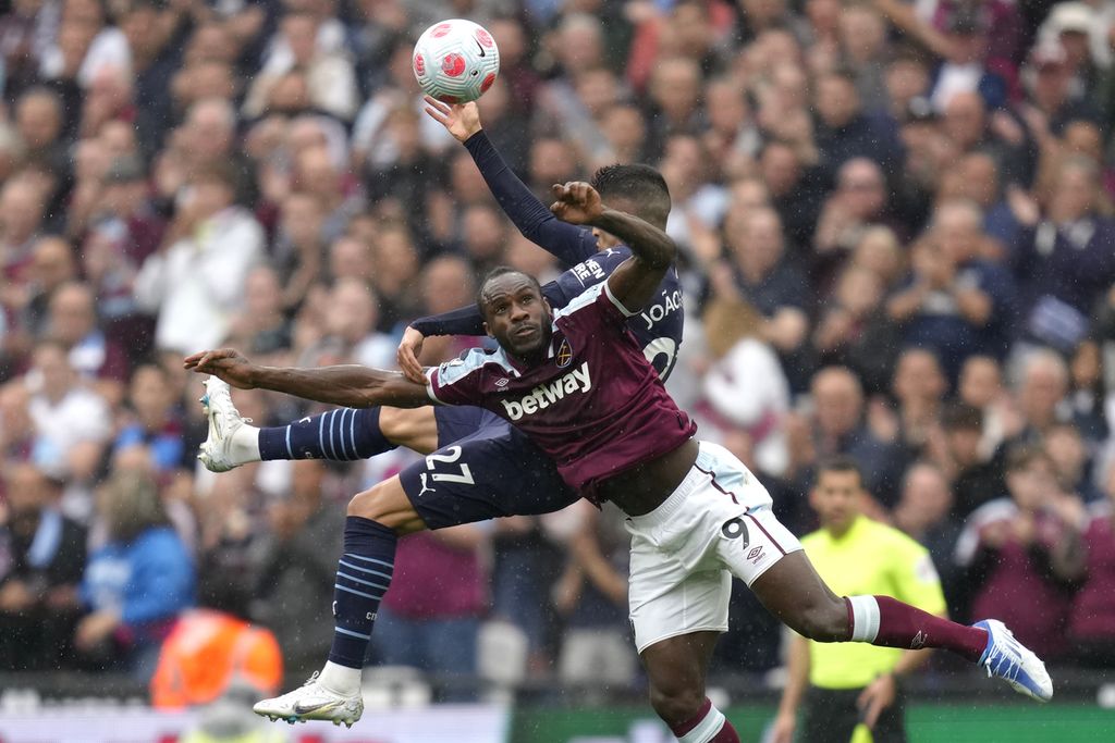 Penyerang West Ham, Michail Antonio (depan), berduel dengan bek Manchester City, Joao Cancelo, pada laga pekan ke-37 Liga Primer Inggris di Stadion London, Inggris, 15 Mei 2022. Pada laga terakhir, Minggu (22/5/2022), City akan berjuang mempertahankan gelar juara Liga inggris dan West Ham berusaha menggeser Manchester United dari posisi keenam klasemen.