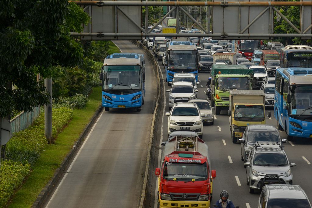 Bus Transjakarta melintas di samping kemacetan di Jalan Mayjen Sutoyo, Jakarta Timur, Senin (9/1/2023).