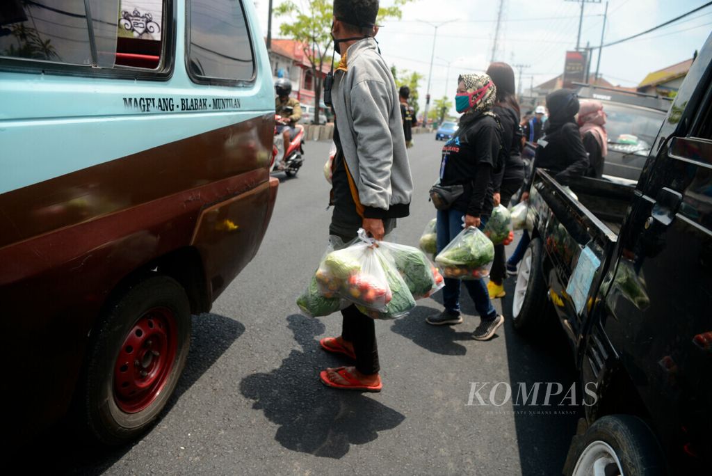 Anggota komunitas media sosial Pakis-Sawangan membawa paket sayur gratis yang akan mereka bagikan untuk warga di Blabak, Kecamatan Mungkid, Kabupaten Magelang, Jawa Tengah, Minggu (13/9/2020). 