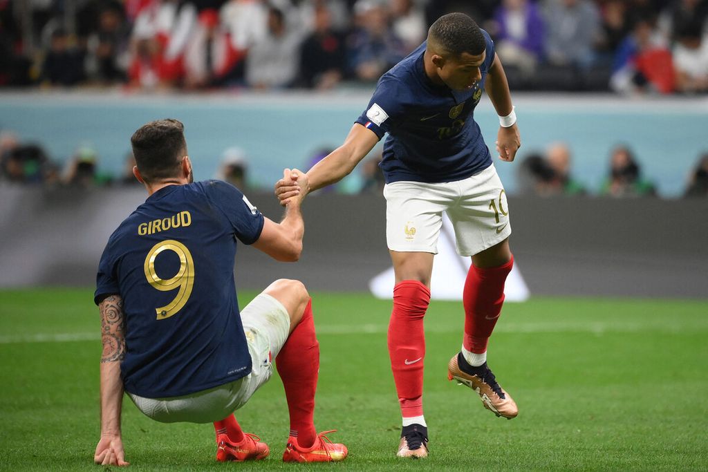 Penyerang Perancis, Kylian Mbappe (kanan), membantu rekannya, Olivier Giroud, bangkit saat pertandingan sepak bola perempat final Piala Dunia Qatar 2022 antara Inggris dan Perancis di Stadion Al-Bayt di Al Khor, utara Doha, Qatar (10/12/2022). 