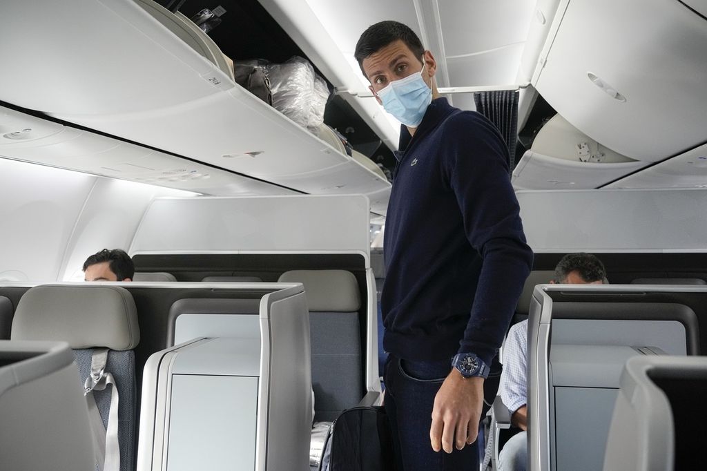 Petenis Serbia, Novak Djokovic, bersiap duduk di pesawat menuju Belgrade di Bandara Dubai, Uni Emirat Arab, Senin (17/1/2022). Djokovic pulang ke negaranya setelah dideportasi dari Australia.